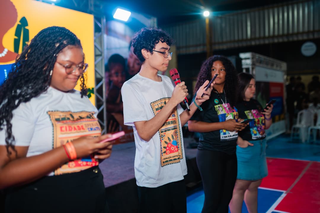 Jovens apresentando projeto em plenária
